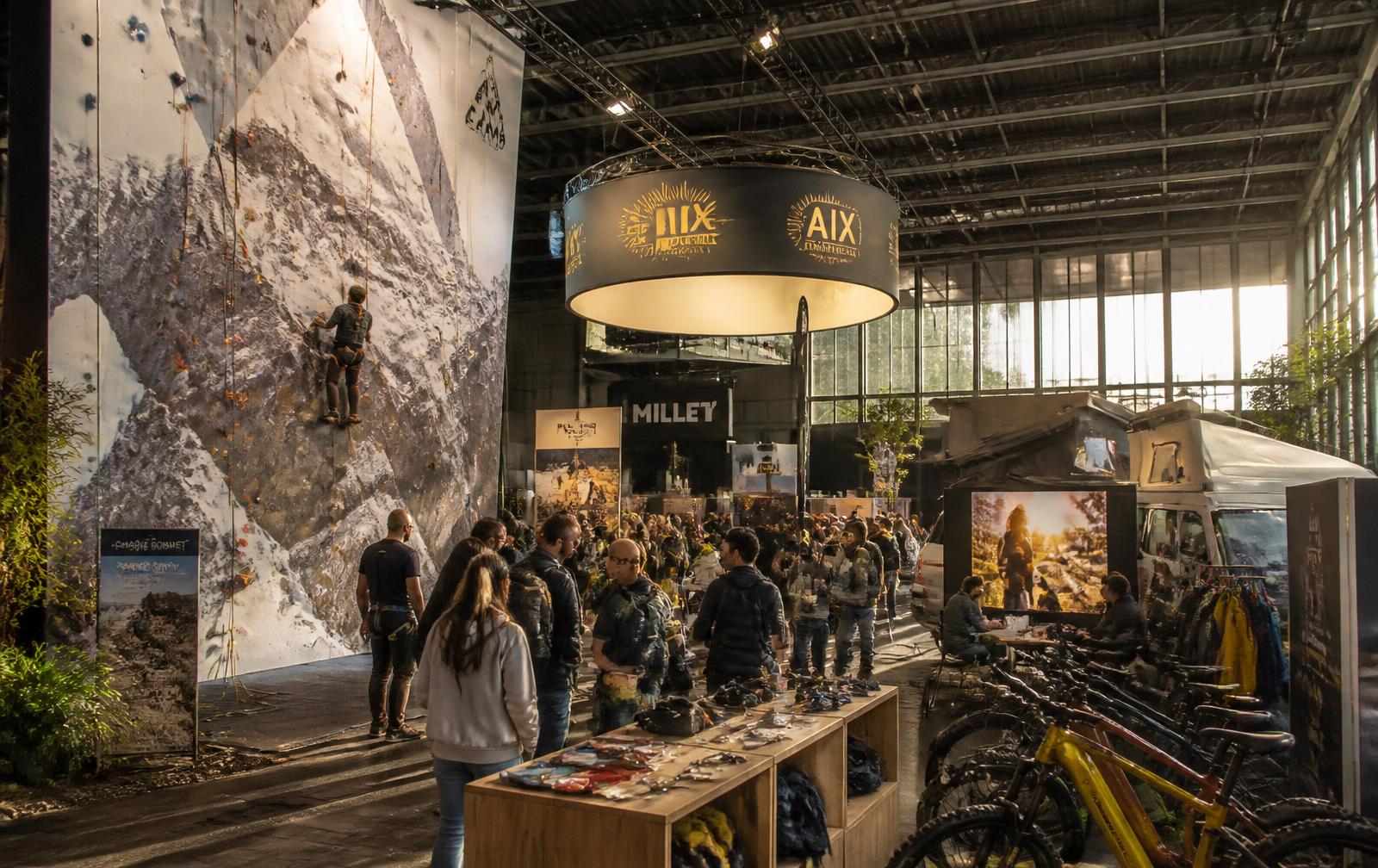 Hall du salon Outdoor et Aventure avec mur d'escalade, vélos et vanlife